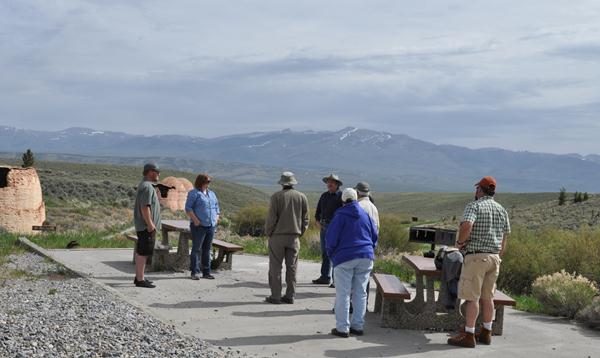 A handful of people listening to Mr. Wright give an outdoor talk. 