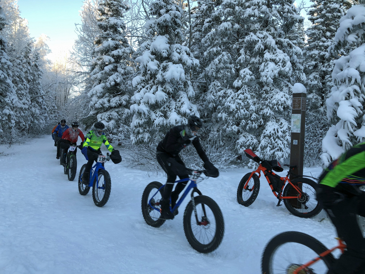Man standing with a fat tire bike and near a posted permit