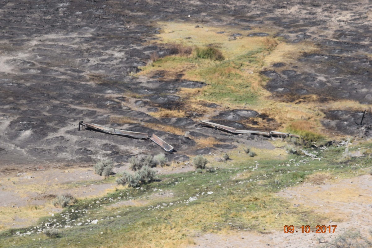A burned portion of public lands with a water development.