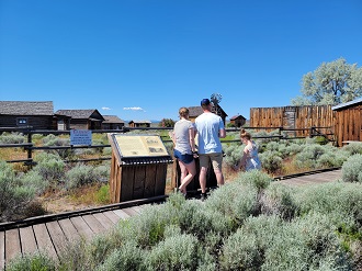 Adam and Jenna Oakes, and daughter Etta Oakes read the info sign at Fort Rock