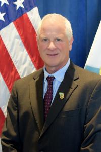 Jeff Krauss stands in front of an American flag