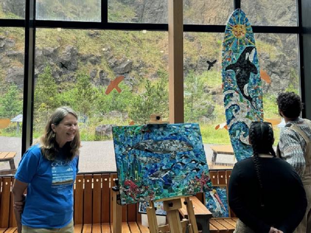 Artist in residence Rena Ekmanis shows off her work to visitors at the Yaquina Head Interpretive Center