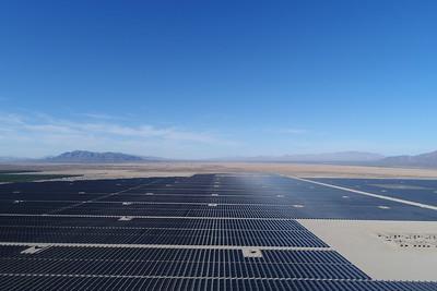 solar array in the desert with mountains in the background. 