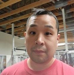 smiling person wearing a red shirt standing indoors