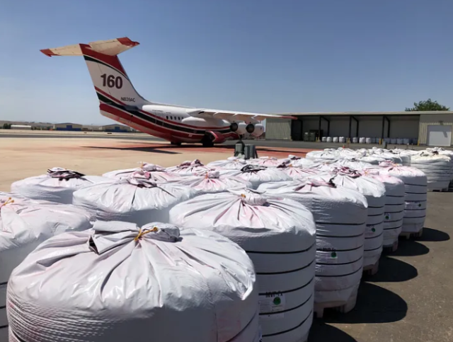 Big plastic bags on the tarmac next to a parked airplane