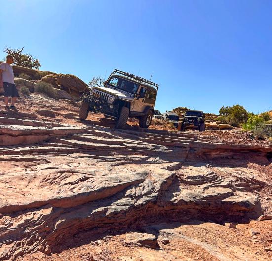 A person in a Jeep lines up for a decent down rock ledges