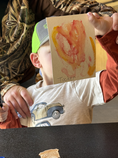 a young boy holds a painted heart