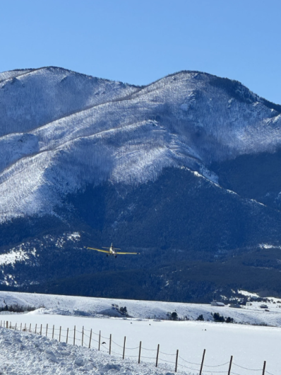Snowy hilly landscape with plane approaching