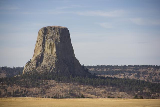 A butte rises above a landscape with trees.