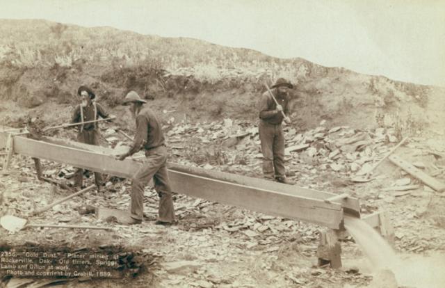 Three men work near a placer mining trough in South Dakota in 1889.