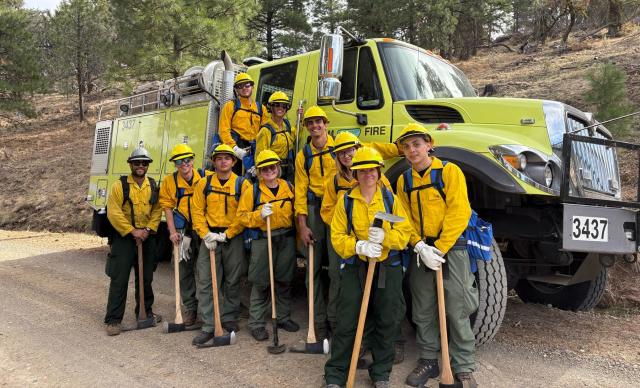 firefighters posing in front of equipment