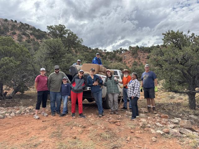 Volunteers stand with a truckload of trash