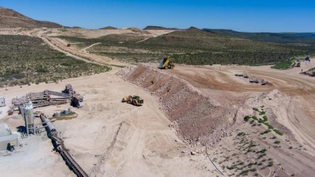 A aerial shot of an open pit mine in the desert.