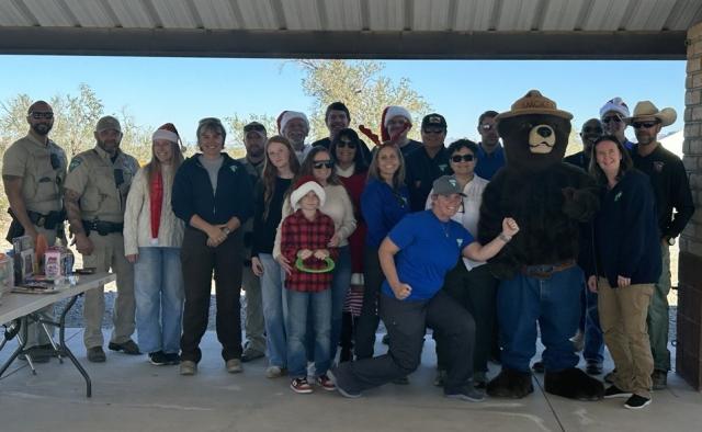 BLM employees and volunteers pose with Smokey Bear, Santa Claus and Mrs. Claus