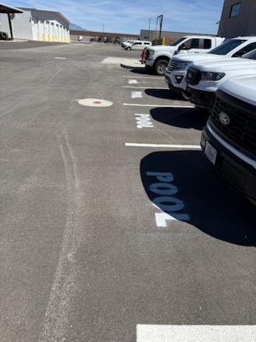 A parking lot with bright, white painted parking stalls labeled for various vehicle types