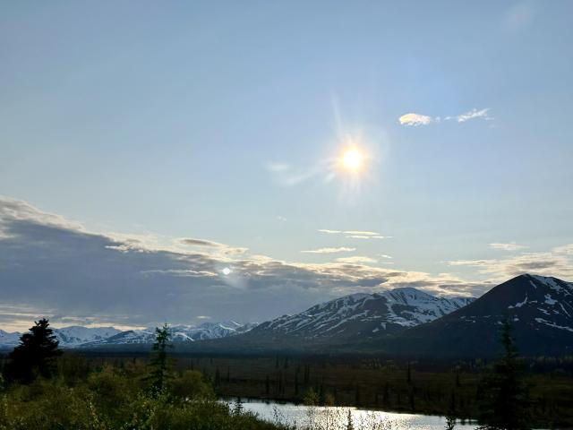 Scenic landscape view of mountains and river valley on a sunny day.