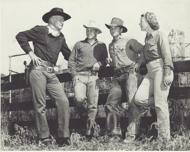 A black and white photo of movie stars dressed up as cowboys
