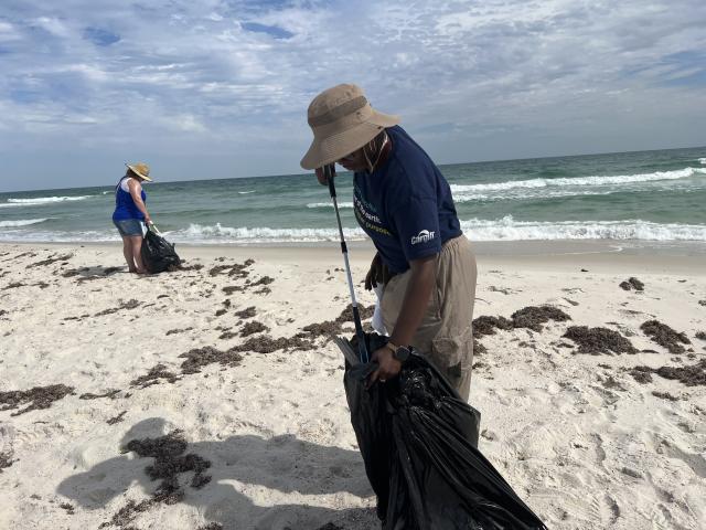 From left to right: Administrative Support Assistant, Angela Dennis and Geologist, Samirra Felix comb the beach for litter to help keep the coastline clean and thriving.