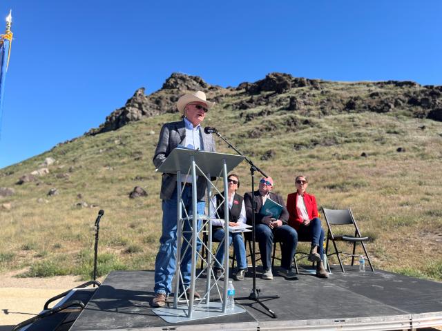 Man in a cowboy hat standing at a podium speaking