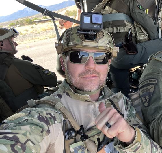 A close up of a man in uniform giving a thumbs up.