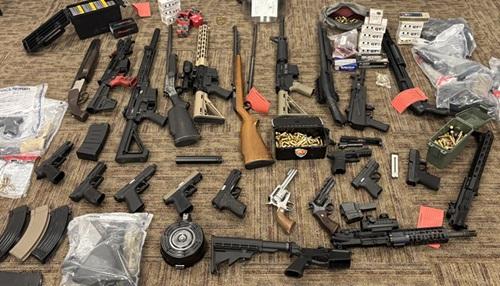 A collections of seized rifles and hand guns.