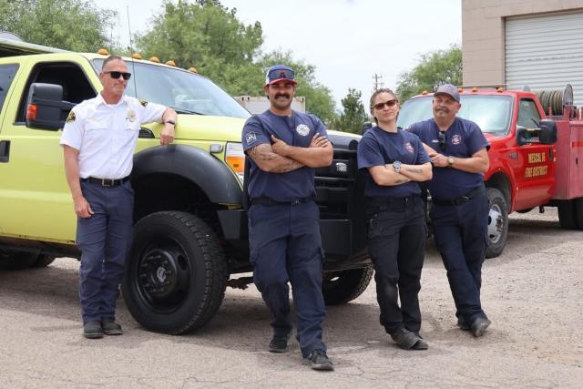 Fire chief and 3 firefighters standing in front of the new fire engine. 