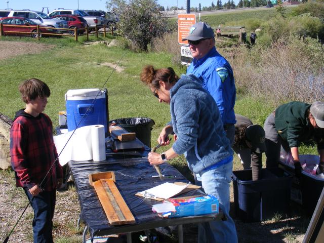 BLM staff help kids weigh in their fish at the annual fishing derby.