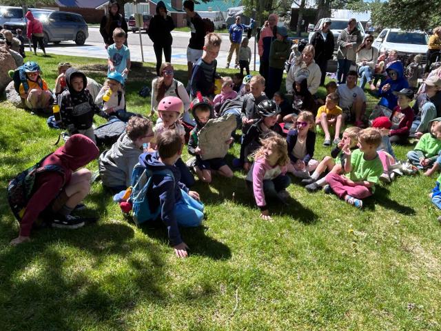  Children hold and pass round real fossils and casts on a sunny day with green grass