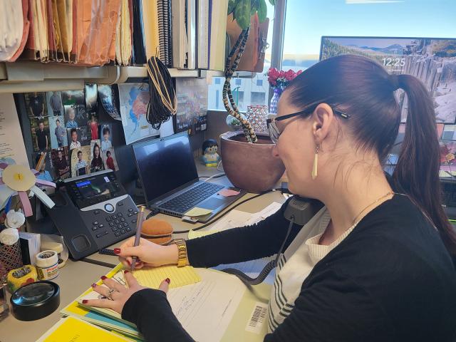  BLM Alaska land law examiners at their desk on the phone and reviewing a case file.