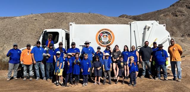 Volunteers and public works staff pose in front of a Yuma County Public Works truck during a desert cleanup event on public lands near Yuma, Arizona.