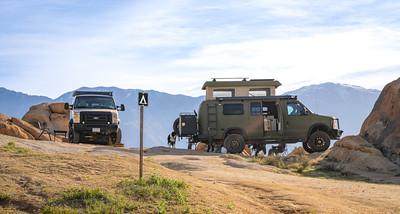 A van in a camping spot in dry tan hills.