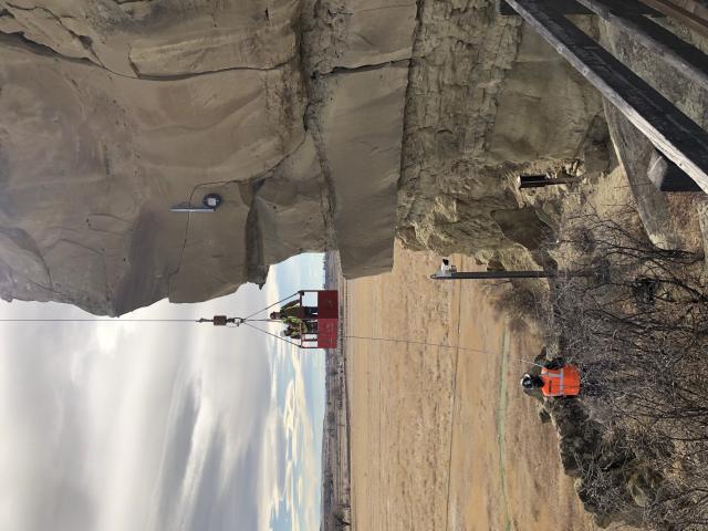 Workers access the south/southeast face of Pompeys Pillar National Monument via crane.
