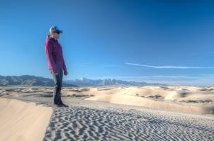 person standing on sand dune