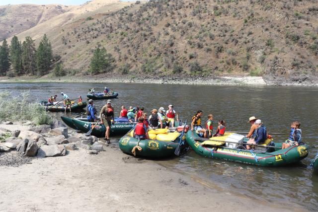 Students ashore in rafts on the river