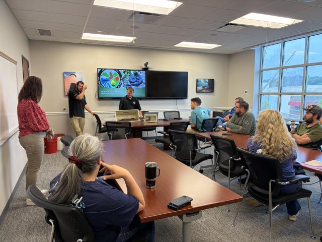 Staff participate in a safety briefing featuring experts discussing wildlife awareness and emergency preparedness.