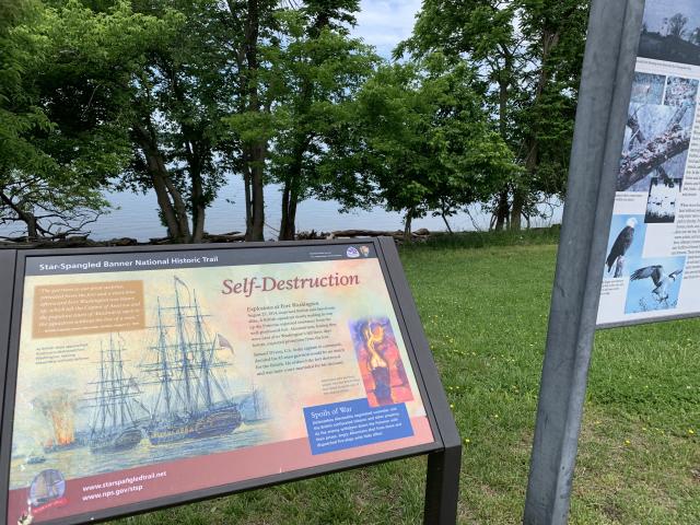 Star‑Spangled Banner National Historic Trail interpretive sign tell the story of historic events overlooking a calm waterfront.
