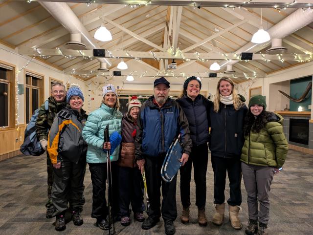 A group of people with a couple of people holding snowshoes.