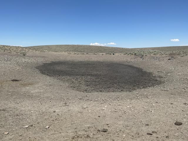 A drying pond in brown barren landscape