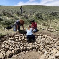 workers build rock structure on ground