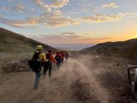Fire crew hiking into the sunset