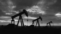 Black and white photo of three oil pump jacks