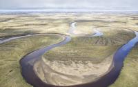 An aerial view of a river snaking through a green landscape.