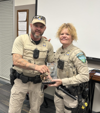Two police officers with award trophy being held by both.