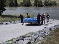 A group of people carry a blue raft of the new boat ramp. 