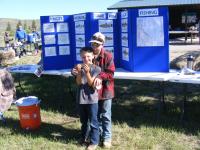 Two kids pose for a photo with their catch of the day, fish.