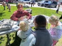 Kids handle fossils at a story time event in Pinedale WY with BLM staff member