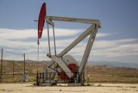 An oil derrick amidst dry hills