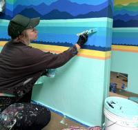 A woman painting a wall