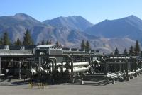 A geothermal plant with large mountains in the background.