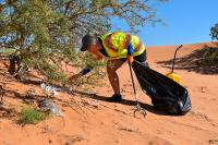 A volunteer picking up litter at the 2026 NPLD event in Carlsbad.